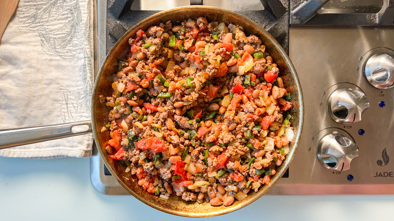 Loaded beef taco casserole filling ingredients in skillet on stove top