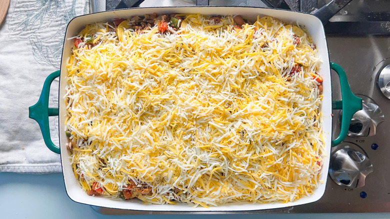 Shredded cheese on loaded beef taco casserole in baking dish