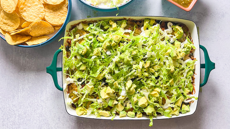 Shredded lettuce and chopped avocado on top of loaded beef taco casserole