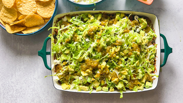 Loaded beef taco casserole in baking dish with tortilla chips