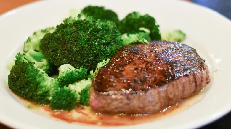 A steak with broccoli on a white plate