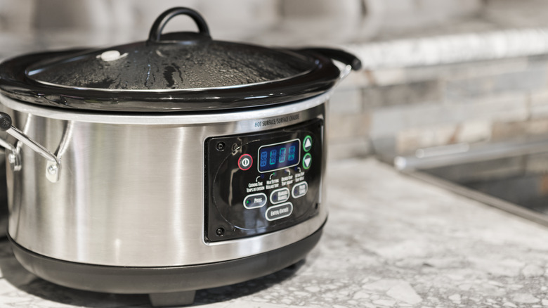 A crockpot on low setting sitting on a kitchen counter