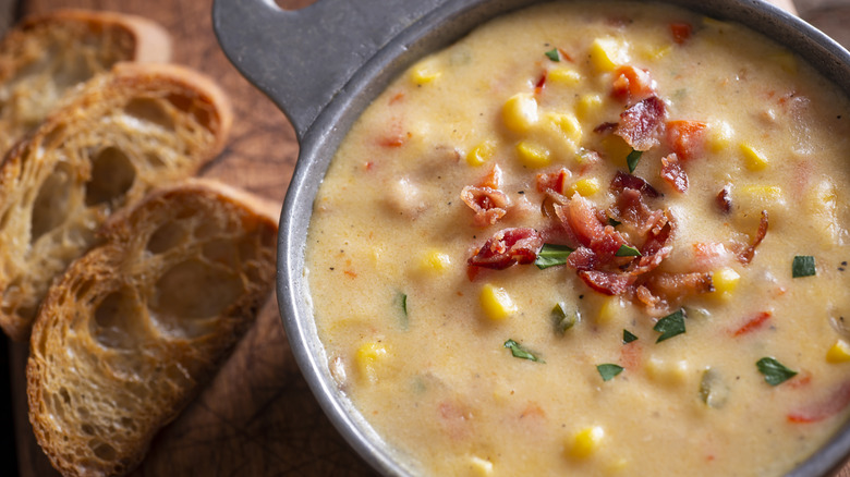 closeup of a bowl of corn chowder with bacon bits on top