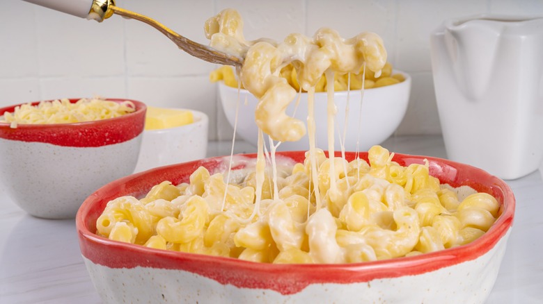 A bite of mac and cheese is lifted onto a fork.