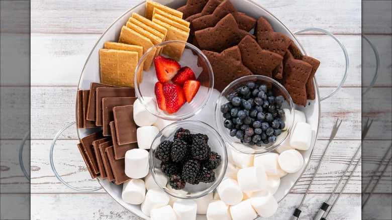 Tray with s'mores ingredients and mixed berries