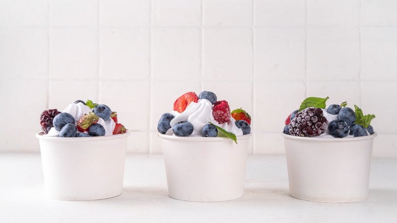 Three cups of frozen yogurt topped with berries