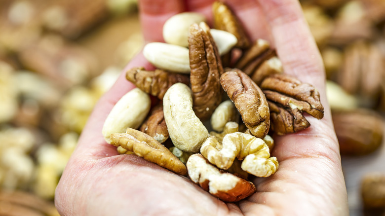 Hand holding a handful of different nuts