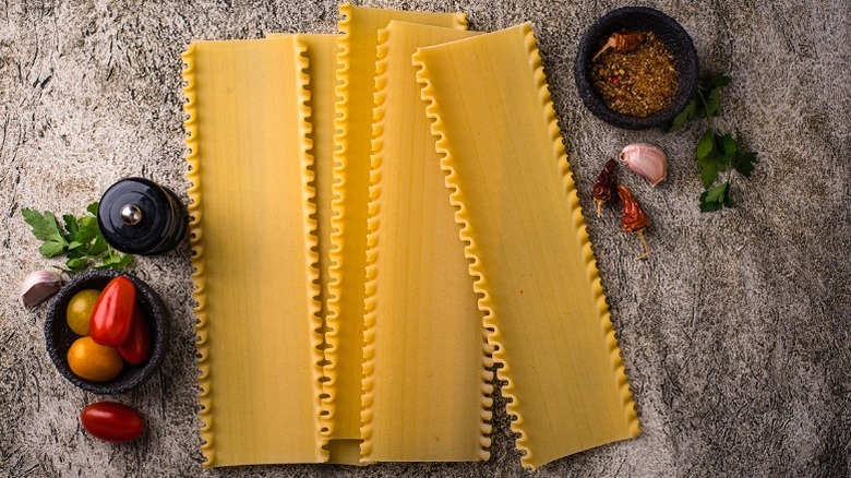 Uncooked lasagna on table with seasonings