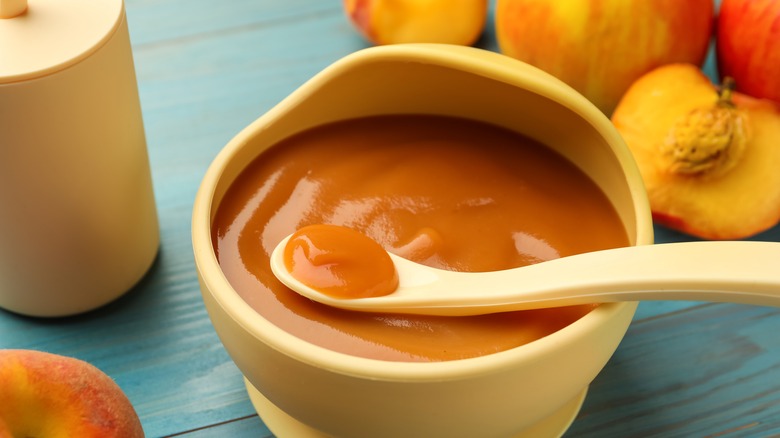 Peach sauce in bowl with peaches