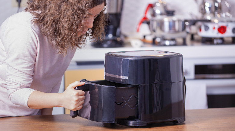 woman using air fryer