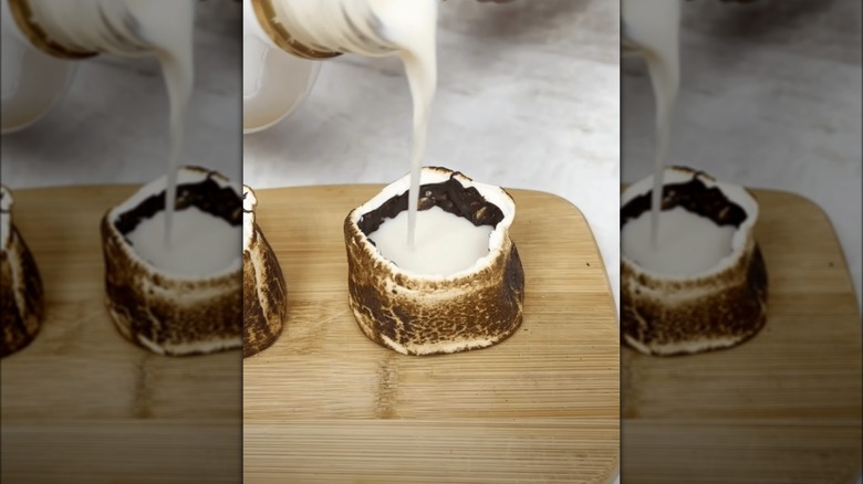 White liquid pouring into edible toasted marshmallow shot glass