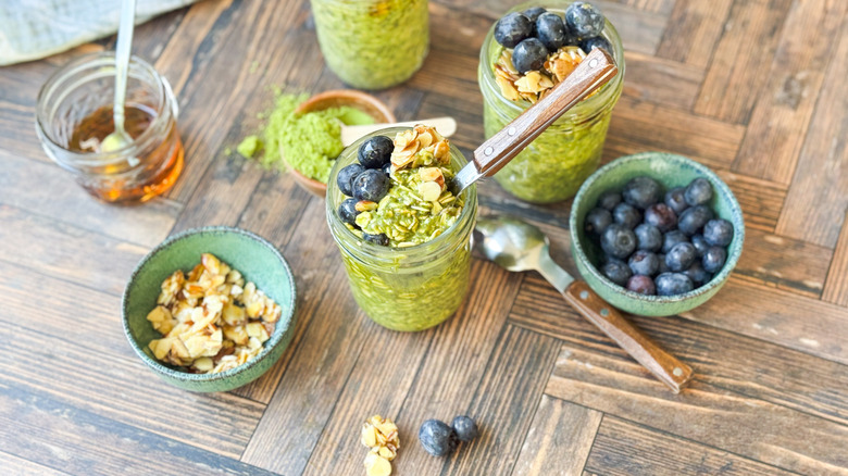 Matcha almond overnight oats in jars with maple almond and blueberry topping