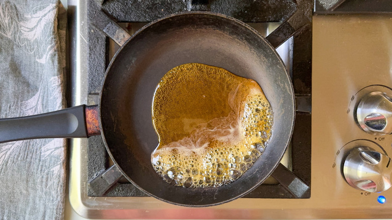 Maple syrup boiling in small skilled on stovetop