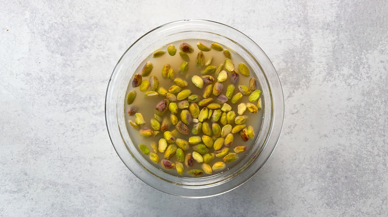 Pistachios soaking in water in glass bowl