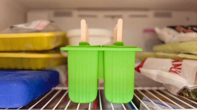 Matcha pistachio popsicles in molds in freezer