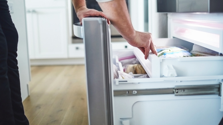 Reaching into a freezer drawer