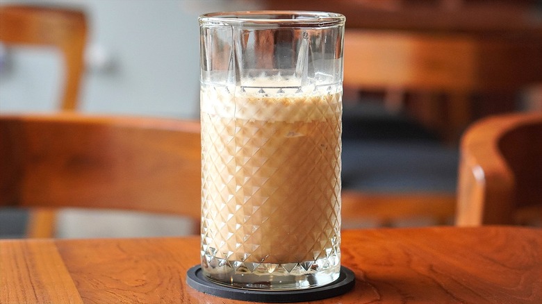 Glass of creamy drink on wooden table