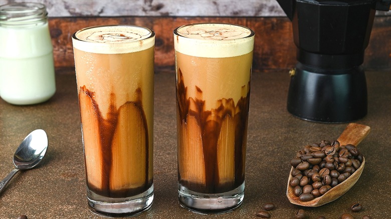 Two blended coffee drinks in glasses lined with chocolate