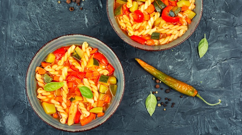 Two bowls of minestrone soup on a table