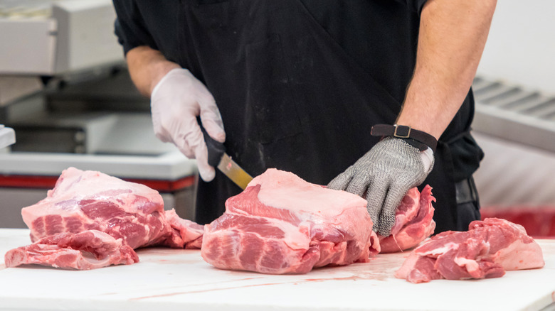 Butcher cutting large piece of meat