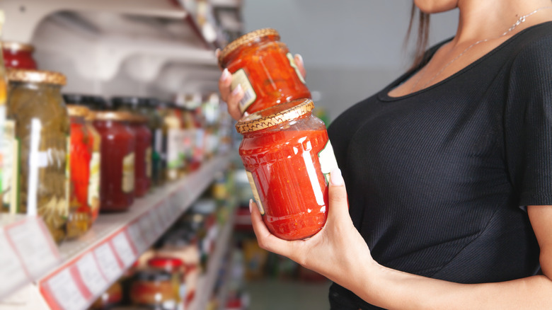 Person holding store-bought pasta sauce