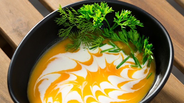 Soup with cream and herbs on top