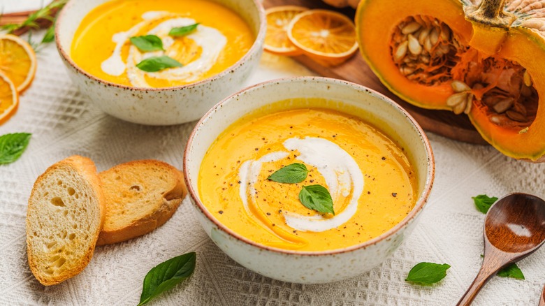 Butternut squash soup with ingredients next to bowl