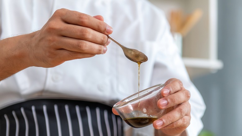 chef mixing dressing in bowl