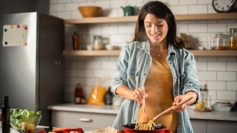 woman cooking pasta in kitchen