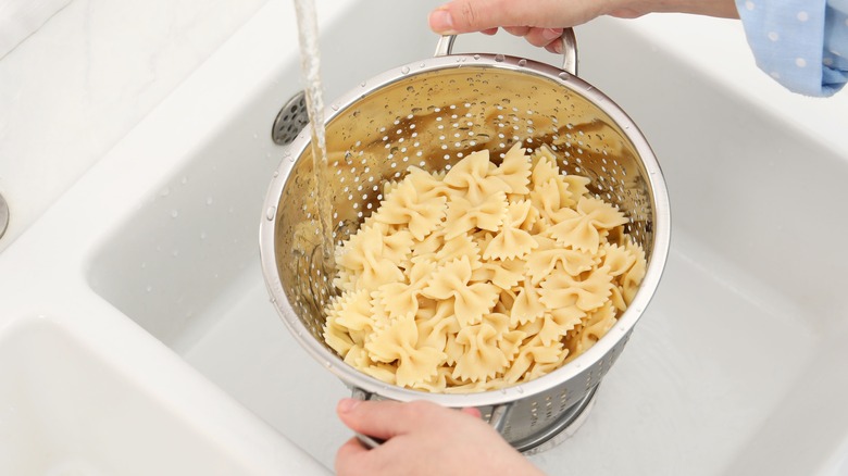 rinsing pasta in the sink