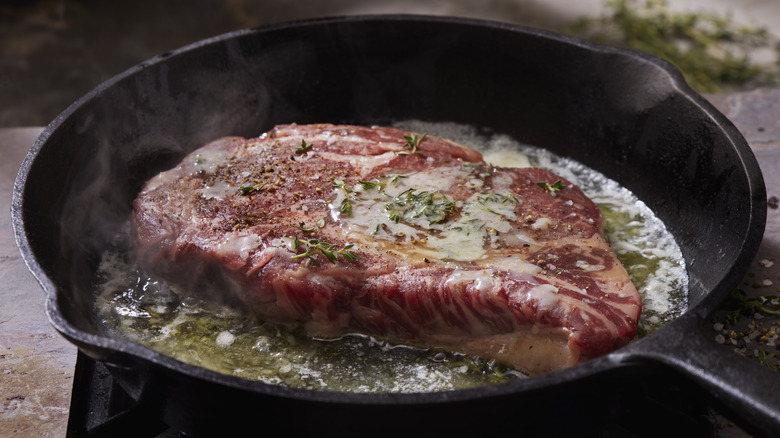 Steak cooking in a cast iron pan