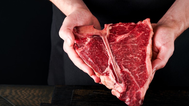 Man holiding raw T-bone steak