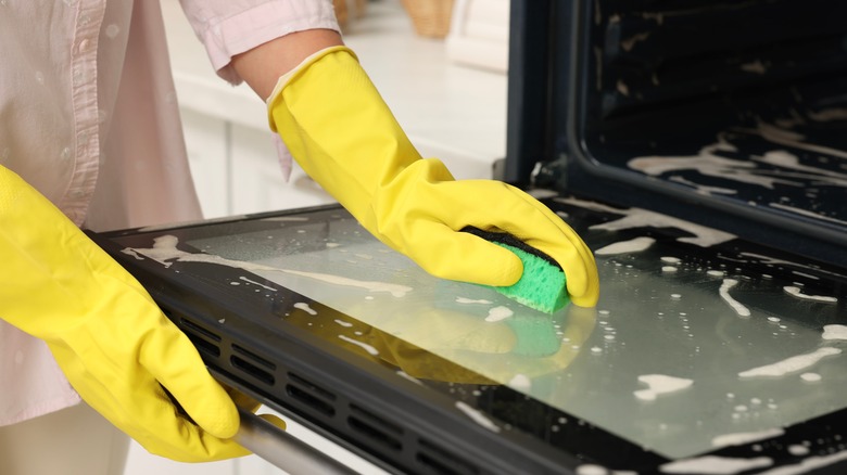 Woman cleaning oven door