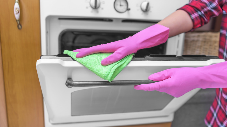 Woman wiping inside of oven