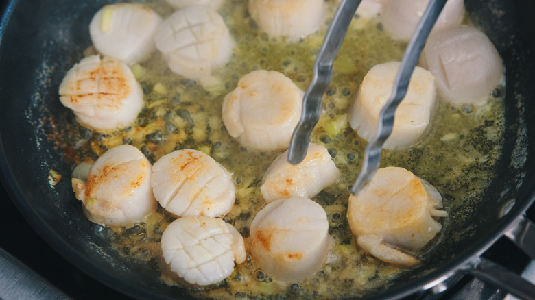 Cook flipping scallops