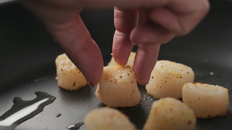 Placing scallops in a pan