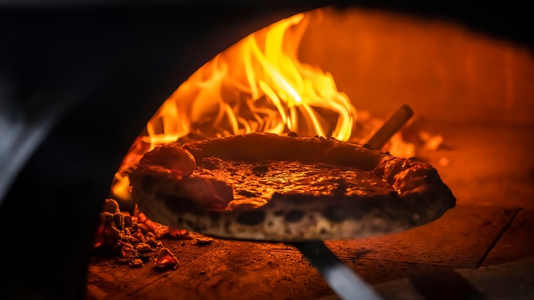 Pulling pizza from the oven