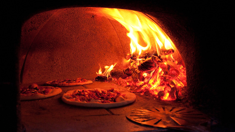 Three pizzas in a pizza oven