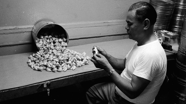 man putting fortunes into cookies