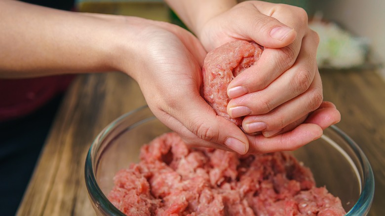 Hands forming beef into balls