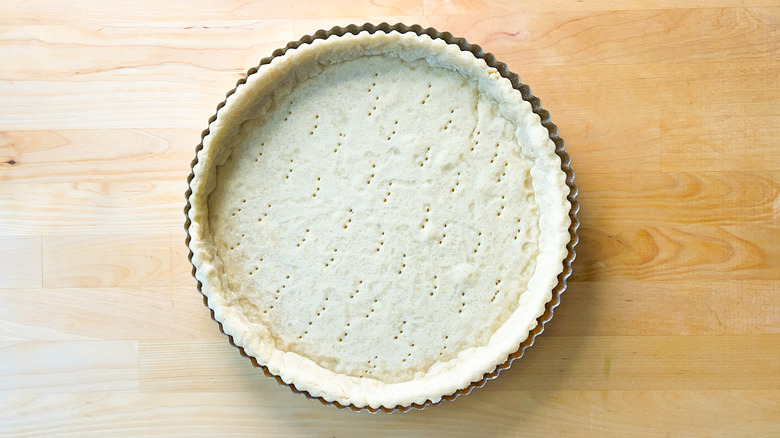 Baked quiche shell in tart pan on counter
