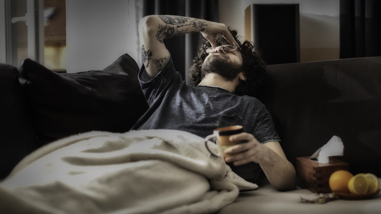 man on couch with hangover