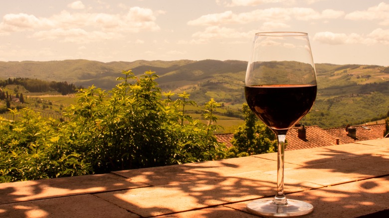 glass of red wine and tuscan hills