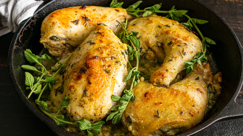 Four skin-on roast chickens in skillet
