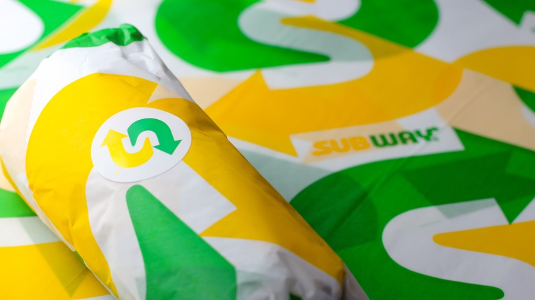 Subway sandwich wrapped in the company's green and yellow branded deli paper