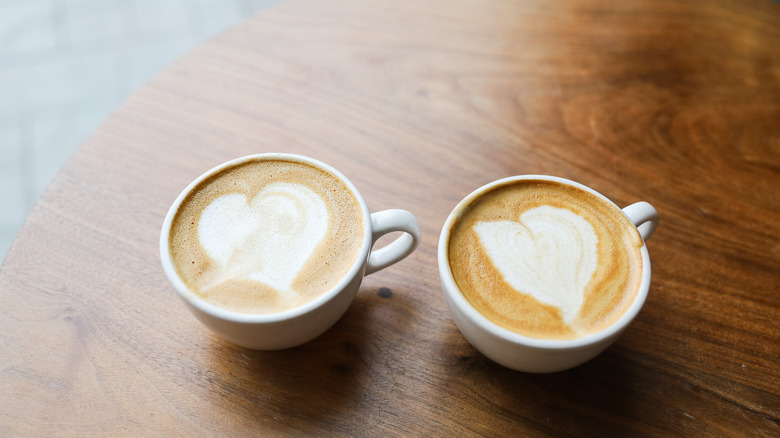 Two lattes on brown table