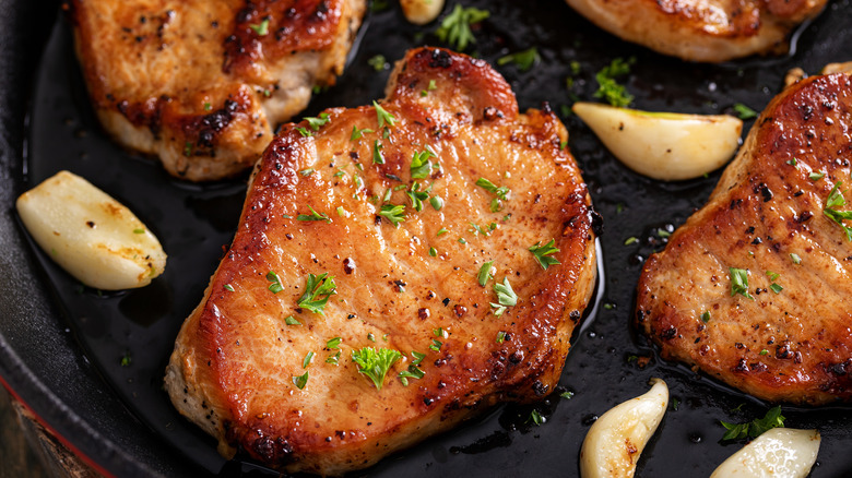 Close up of pork chops with garlic and herbs