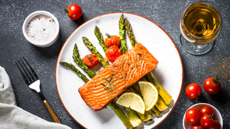 Salmon over asparagus and tomatoes with white wine