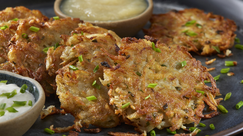 A plate of latkes with sauces on the side