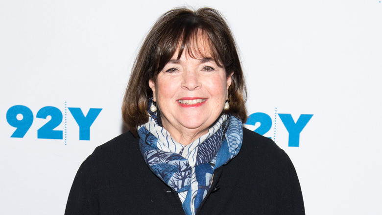 Ina Garten is standing in front of an event backdrop.